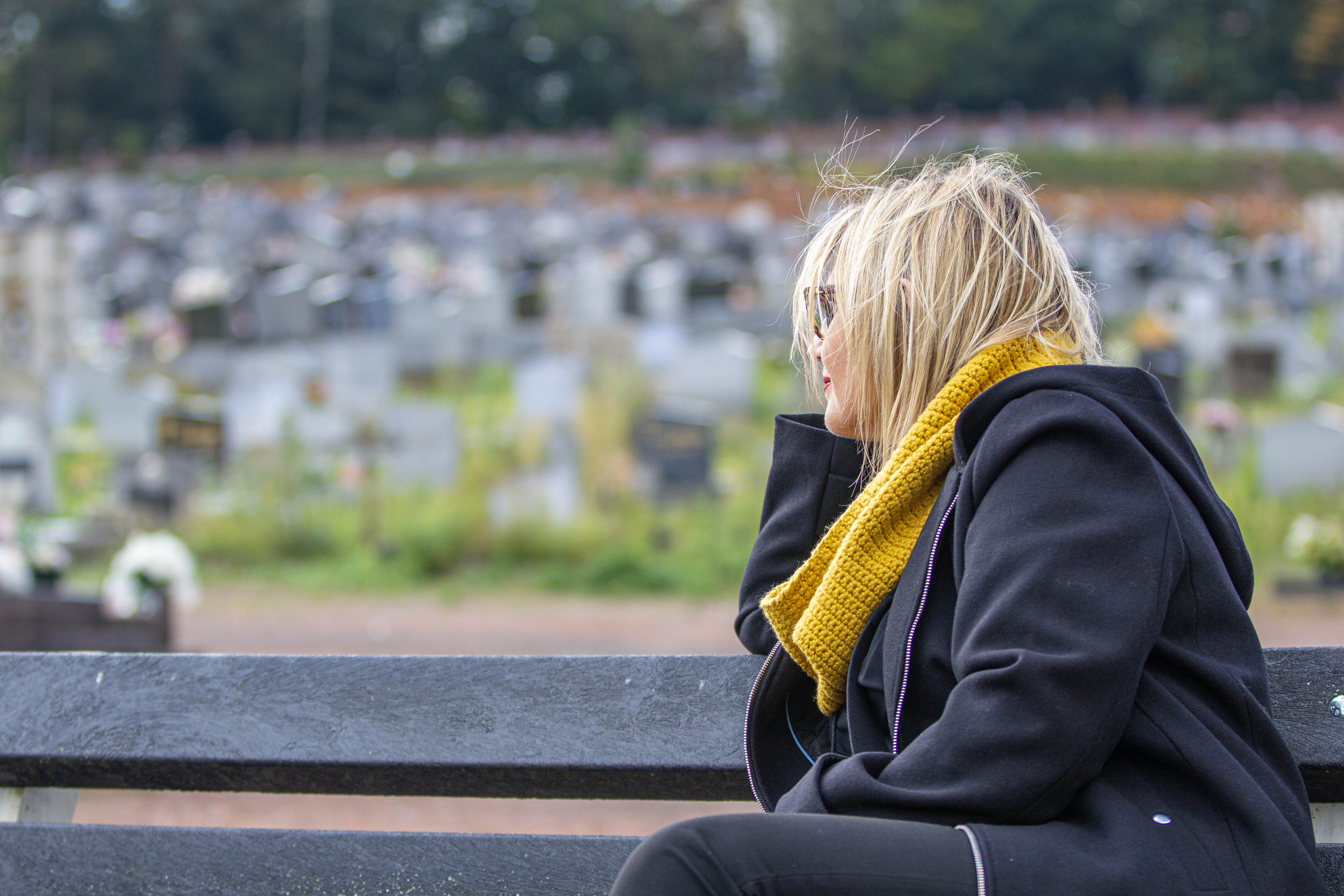 Sabine Roberty, assise sur un banc du cimetière de la Bergerie à Seraing