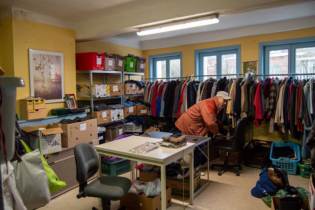 Un bénéficiaire fouille parmi les vêtements pour trouver la perle