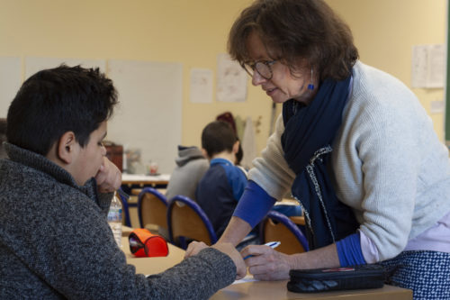 L'institutrice aide un enfant réfugié.