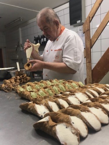 Giovanni est occupé à remplir le cannolo au chocolat.