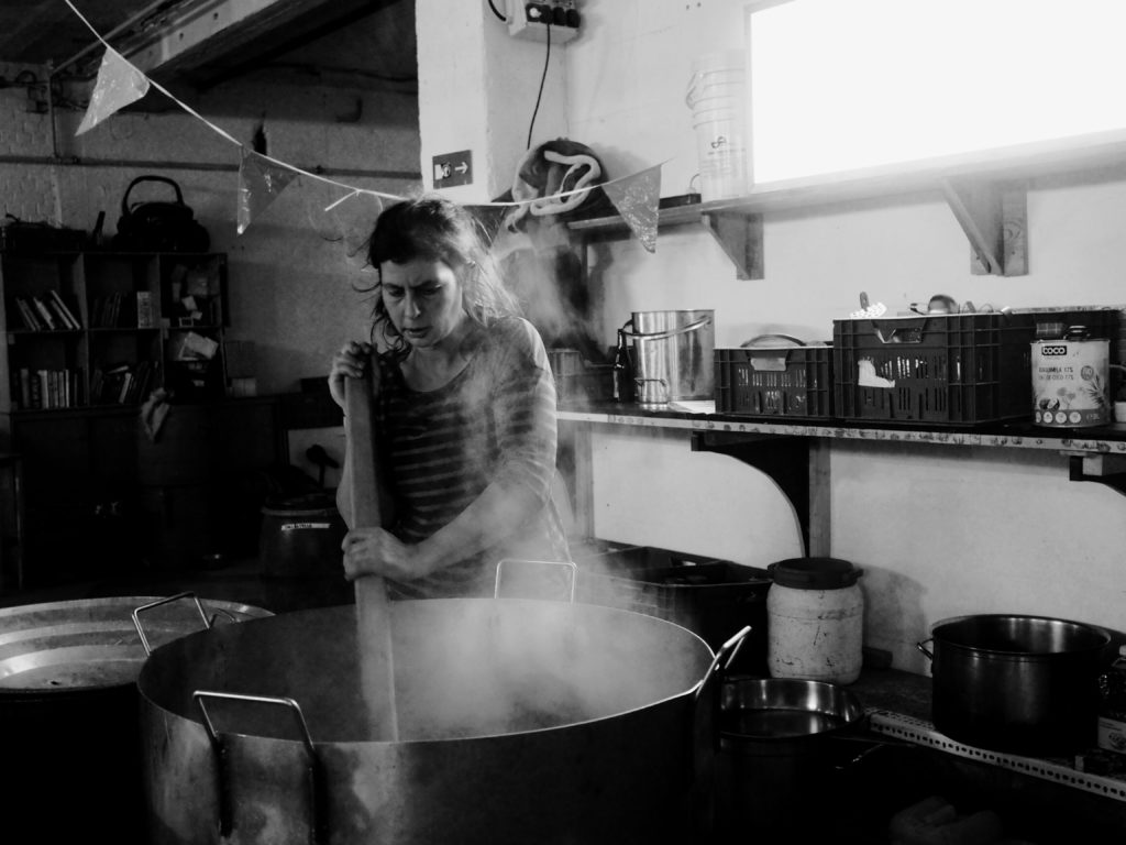 Une femme touille dans une énorme casserole