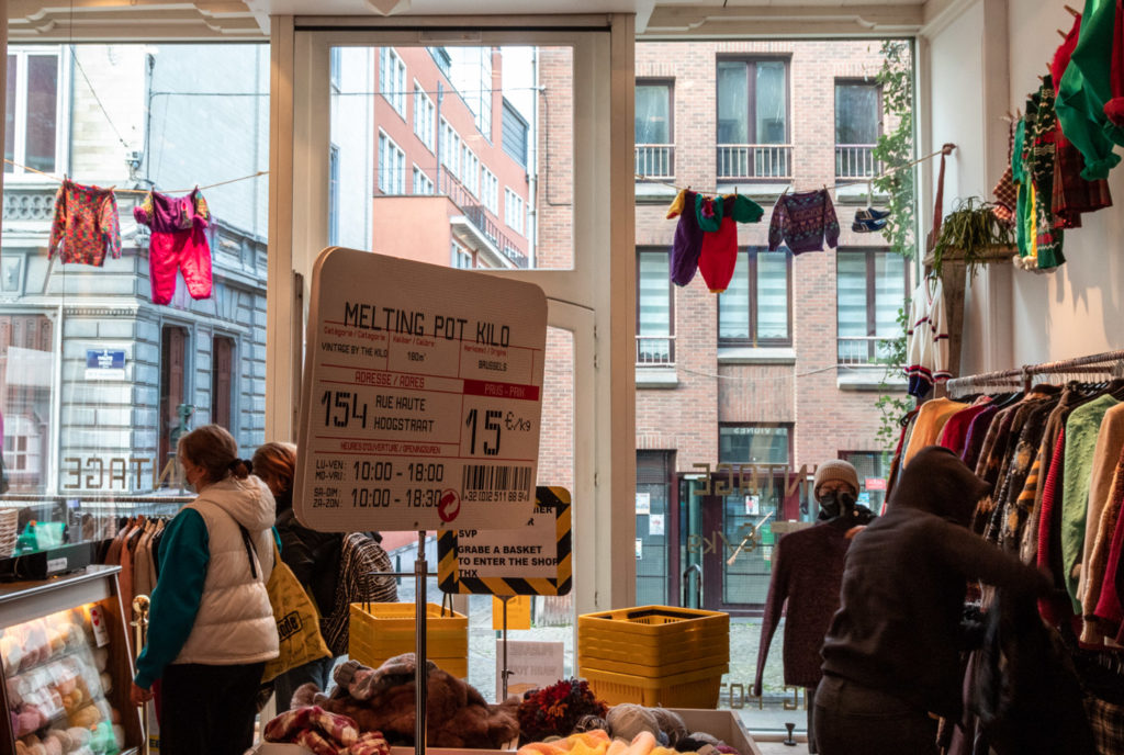Pancarte dans un magasin de vente de vêtements au kilo.