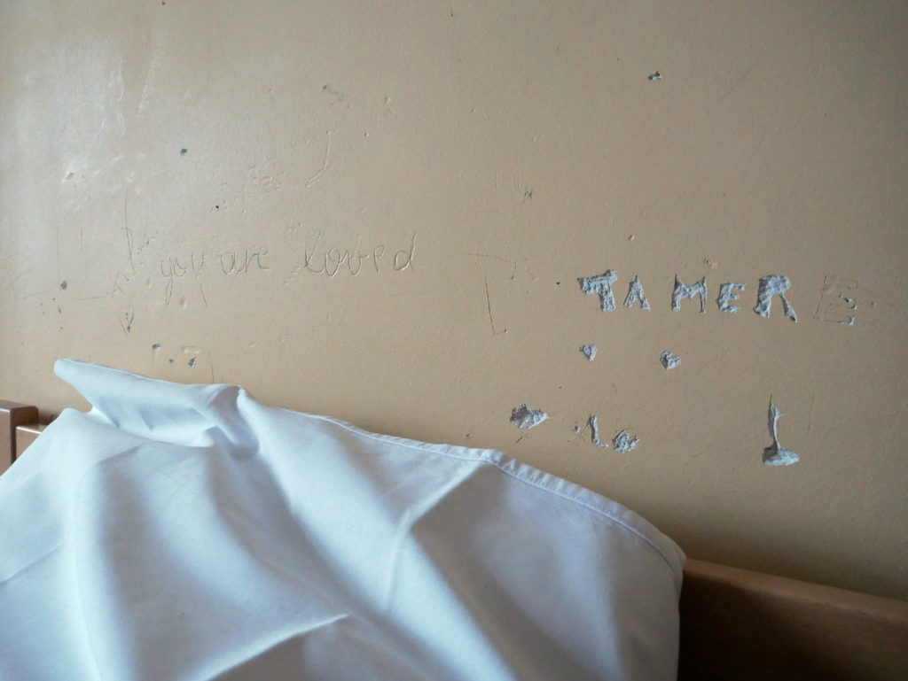 inscriptions sur le mur d'une chambre "Ta Mere" "You are loved"