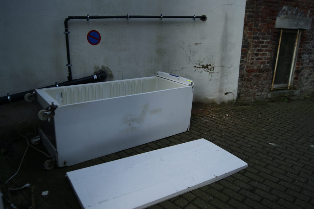 Frigo démonté couché sur le sol