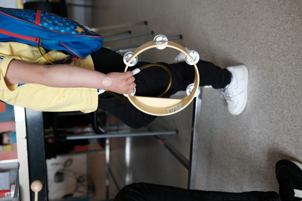 Enfant qui tient un instrument de musique.