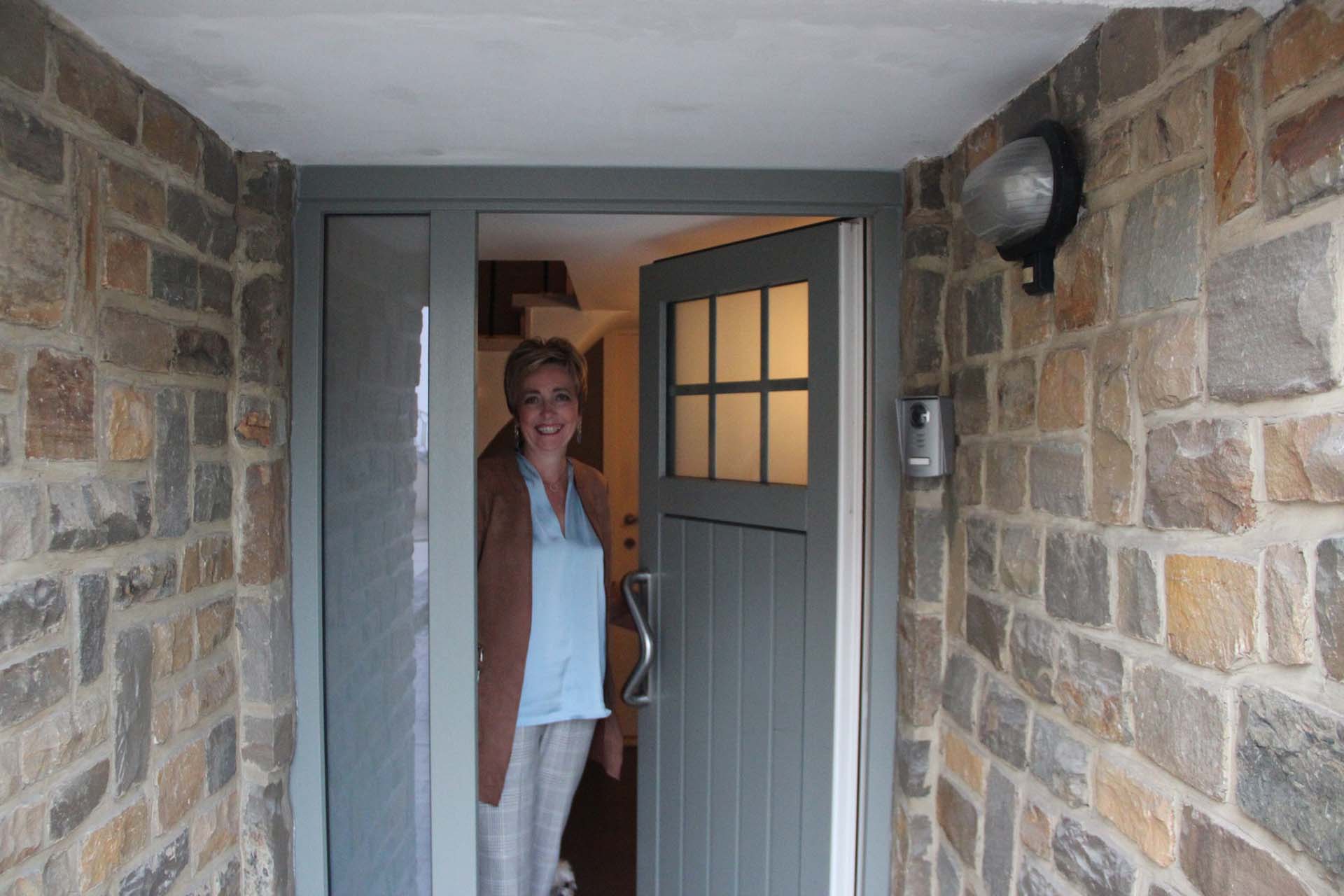 Voisine qui sourit à l'entrée de sa maison