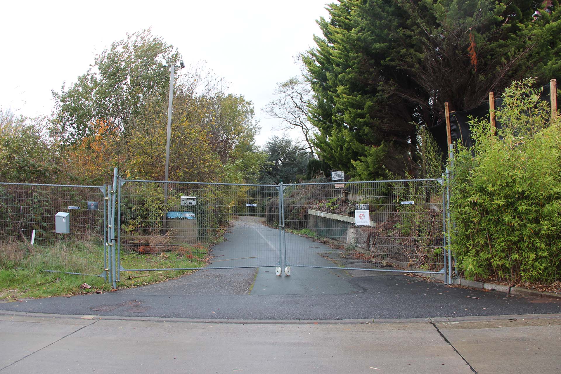 Entrée du campus du Bierenberg fermée par des barrières Heras, route qui mène vers le campus