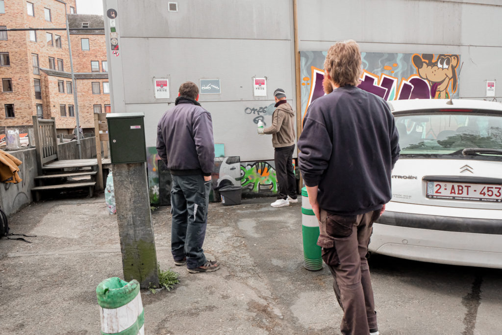 Des membres retirent des graffitis du mur extérieur de l'UTUC