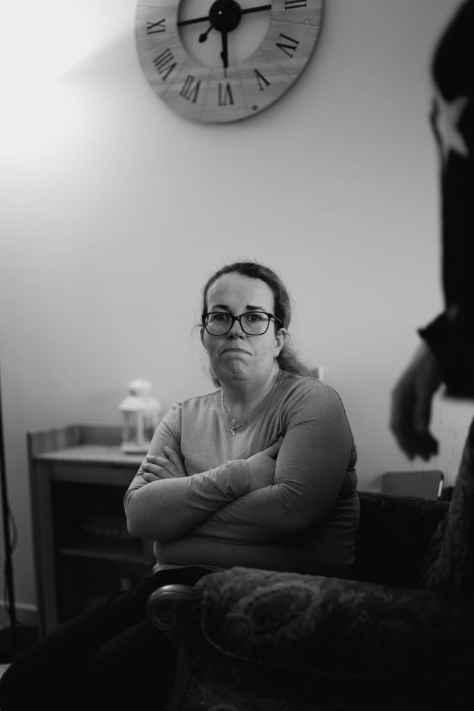 Marie dans son canapé, face à la caméra.