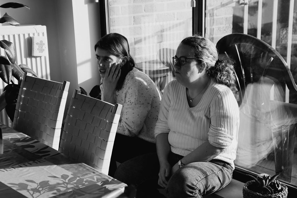 Chloé et Marie sont assises, écoutant leur éducatrice qui rappelle les règles.